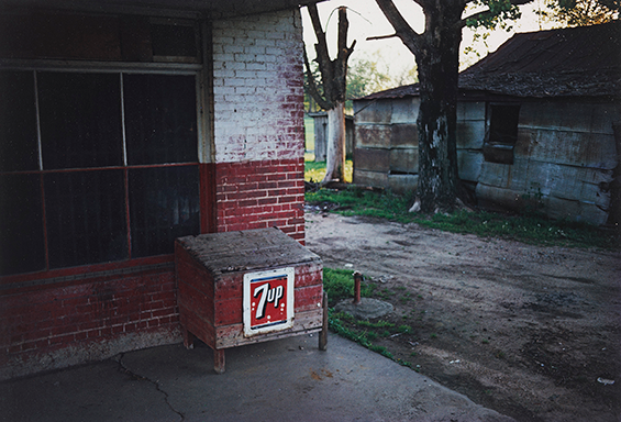 photo of a red brick building and a white abandoned building